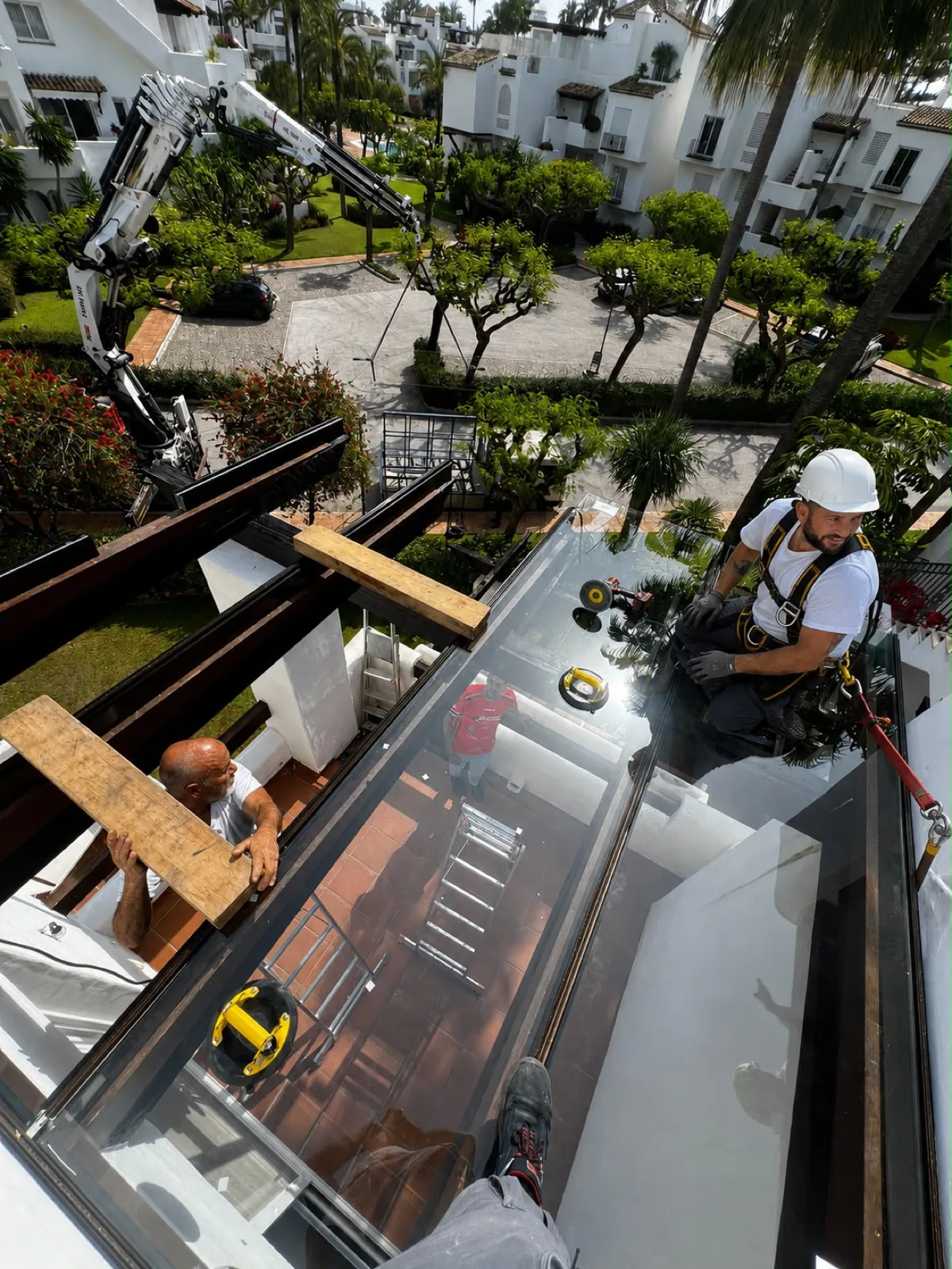 Instalación de un gran cristal con grúa por Montajes Juan en Marbella